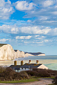 View of the Seven Sisters cliffs and the coastguard cottages, from Seaford Head across the River Cuckmere. Seaford, Sussex, England, United Kingdom.