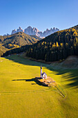 Aerial view of Ranui church with the Odle group in the background. Santa Magdalena Val di Funes, Funes Valley, Bolzano, South Tyrol, Trentino Alto Adige, Italy.