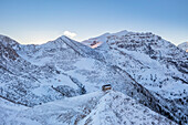 Aerial view of the small church at the top of the Manina Pass, between Scalve Valley and Seriana Valley at sunset in winter. Nona, Vilminore di Scalve, Scalve Valley, Lombardy, Bergamo province, Italy.