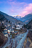 Das Dorf Gromo mit dem bei Sonnenuntergang beleuchteten Pizzo Redorta im Hintergrund. Gromo, Val Seriana, Provinz Bergamo, Lombardei, Italien, Europa.
