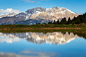 View of the Presolana mountain reflected on a spring pond on Monte Pora. Songavazzo, Val Seriana, Bergamo district, Lombardy, Italy, Southern Europe.