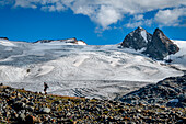 Trekker mit dem Rutor-Gletscher im Hintergrund, nahe der Deffeyes-Hütte, Rutor und Vedette-Gipfel im Hintergrund, La Thuile-Tal, Aostatal, Italien, Europa