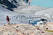 Trekker admire Rutor glacier, close to Deffeyes refuge, La Thuile valley, Aosta Valley, Italy, Europe