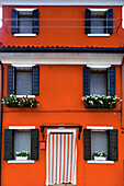 Burano, typical colored houses, red house; Burano, Venice, Veneto, Italy, south Europe.