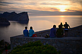 Menschen genießen den Sonnenuntergang vom Leuchtturm Cap de Formentor, Mallorca, Spanien