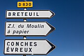 Straßenschild, das die verschiedenen Richtungen der Departementstraße d830 mit den Namen der Städte und des Industriegebiets der Papierfabrik Moulin a Papier anzeigt, Rugles, Eure, Normandie, Frankreich