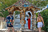 Passing reader in front of a second-hand book kiosk, exchange kiosk buit of books, aniane, herault, occitanie, france