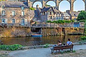Family on the banks of the rance beneath the viaduc, medieval town of dinan, cotes-d'amor, brittany, france