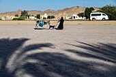 Veiled woman with her donkey and goat in front of a coffee shop dans le desert, qena, egypt, africa