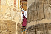 Woman on scaffolding for the restoration works on the columns of the great hypostyle hall, precinct of amun-re, temple of karnak, ancient egyptian site from the 13th dynasty, unesco world heritage site, luxor, egypt, africa
