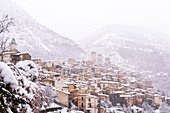Das mittelalterliche Dorf Pacentro unter starkem Schneefall mit dem Schloss, dem Glockenturm und dem schneebedeckten Haus, Gemeinde Pacentro, Nationalpark Maiella, Provinz L'aquila, Abruzzen, Italien