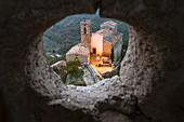 Frau bewundert Kirche von einem Loch der Festung von Roccascalegna aus gesehen, Provinz Chieti, Abruzzen, Italien