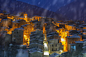 Schneefall in der Abenddämmerung auf das beleuchtete Bergdorf Scanno, Nationalpark Abruzzen, Provinz L'aquila, Abruzzen, Italien