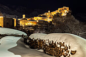 Nächtlicher Blick auf das beleuchtete, schneebedeckte Dorf Villalago, Nationalpark Abruzzen, Provinz L'aquila, Abruzzen, Italien