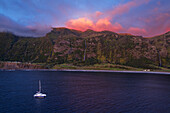 Bucht von Faja Grande mit Wasserfall Poco do Bacalhau und Boot in der Abenddämmerung, Faja Grande, Lajes das Flores, Insel Flores (Ilha das Flores), Azoren Archipel, Portugal, Europa