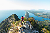 Rear view of a hiker admiring Paola lake and Sabaudia's beach on his route to the peak of Circeo mountain, San Felice Circeo, Circeo National Park, Pontine flats, Latina province, Latium, Central Italy, Italy, Southern Europe, Europe