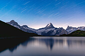 Star trail over Schreckhorn peak reflected in Bachalpsee lake, Grindelwald, Bernese Oberland, Bern Canton, Switzerland