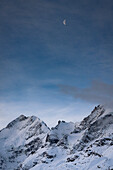 Sunrise over the snowcapped Biancograt mountain ridge and Piz bernina in winter, canton of Graubunden, Engadine, Switzerland