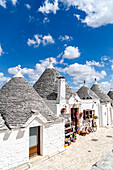 Strahlender Sonnentag über Trulli-Häusern in der alten Gasse von Alberobello, Provinz Bari, Apulien, Italien