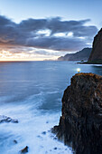 Aerial view of hiker with headtorch standing on top of cliffs at dusk, Madeira, Portugal