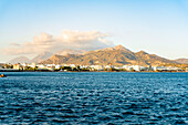 Küstendorf Ierapetra und Berge bei Sonnenuntergang von einer Bootstour aus gesehen, Insel Kreta, Griechenland