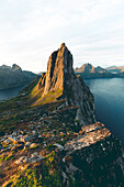 Dramatischer Himmel bei Sonnenaufgang über den hohen Felsen des Berges Segla, Insel Senja, Provinz Troms, Norwegen