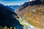 Luftaufnahme der Bergdörfer Bondo und Castasegna, umrahmt von herbstlichen Wäldern, Val Bregaglia, Kanton Graubünden, Schweiz