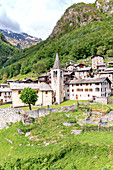 Alter Glockenturm und Häuser umgeben von grünen Wäldern, Savogno, Valchiavenna, Valtellina, Provinz Sondrio, Lombardei, Italien