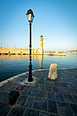 Sonnenuntergang über dem alten Leuchtturm im venezianischen Hafen von Rethymno, Insel Kreta, Griechenland