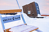 Holzhüttenzimmer des Arktischen Badehotels schwimmend auf dem zugefrorenen, schneebedeckten Fluss Lule, Harads, Lappland, Schweden