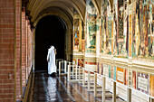 Monk is walking in the cloister of Ancient Church Abbazia di Monte Oliveto Maggiore. Asciano, Siena, Tuscany, Italy, Europe.