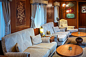 Exclusive sofas inside Inisde of one of living room lounge carriage of Transcantabrico Gran Lujo luxury train travellong across northern Spain, Europe.