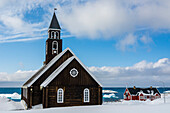 Rückansicht der Zionskirche aus dem späten 18. Jahrhundert, neben einem traditionellen Haus. Ilulissat, Grönland.