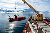 Ein motorisiertes Floß wird von einem Kreuzfahrtschiff in der Mushamna-Bucht zu Wasser gelassen. Insel Spitzbergen, Svalbard, Norwegen.