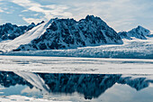 Monaco Glacier and its mirror reflection on arctic waters. Monaco Glacier, Spitsbergen Island, Svalbard, Norway.