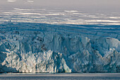 Sonnenlicht und Schatten beleuchten einen Gletscher vor dem Magdalenefjord. Magdalenefjord, Insel Spitzbergen, Svalbard, Norwegen.