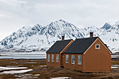 Colorful buildings near mountains and arctic waters at the research station, Ny-Alesund. Ny-Alesund, Kongsfjorden, Spitsbergen Island, Svalbard, Norway.