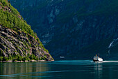 A cruise ship navigates Geirangerfjord, Geirangerfjord, Norway.