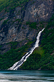 Ein Wasserfall stürzt in den Geirangerfjord. Geirangerfjord, Norwegen.