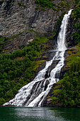 Die Sieben-Schwestern-Wasserfälle stürzen von steilen Klippen in den Geirangerfjord. Geirangerfjord, Norwegen.