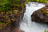A waterfall surges past rock outcroppings near Trollstigen road. Near Trollstigen, Rauma, Norway.