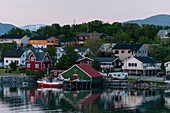 Die bunt bemalten Häuser der Küstenstadt Broennoysund spiegeln sich im Hafen. Broennoysund, Bronnoy, Nordland, Norwegen.