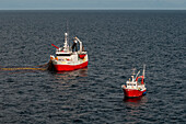 Fischerboote werfen in der Nähe von Stamsund auf der Insel Vestvagoya im Vestfjorden ihre Netze aus. In der Nähe der Insel Vestvagoya, Lofoten, Norwegen.