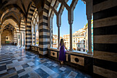 Blondes Mädchen beim Spaziergang in der Kathedrale von Amalfi. Amalfi, Amalfiküste, Provinz Salerno, Kampanien, Italien.