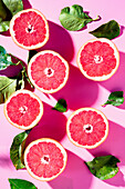 Halbierte rosa Grapefruits mit Blättern