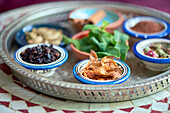 Verschiedene Kräuter und Gewürze für orientalische Gerichte in kleinen Schalen, im Vordergrund Muskatblüten