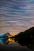 Star trails over a lake, time-lapse image