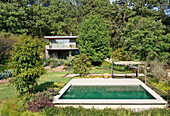 Üppiger Garten mit Schwimmbecken, im Hintergrund Haupthaus