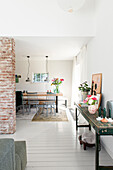 View from living room to brick wall and bright dining area with floral decorations