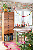 Dining room with vintage furnishings, garden gnome collection on windowsill, Christmas tree in the foreground